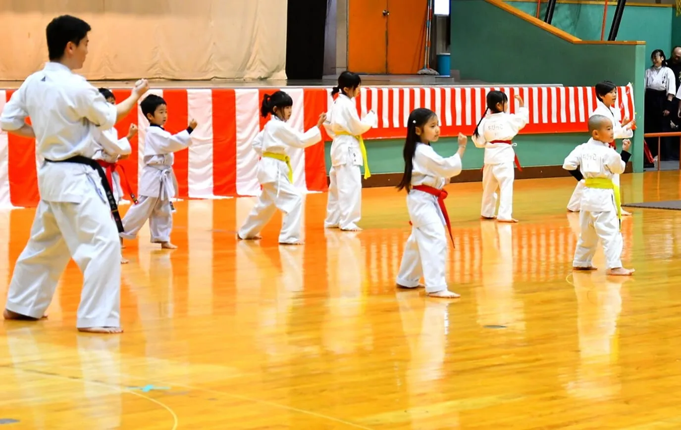 Young children performing kata at a gymnasium event